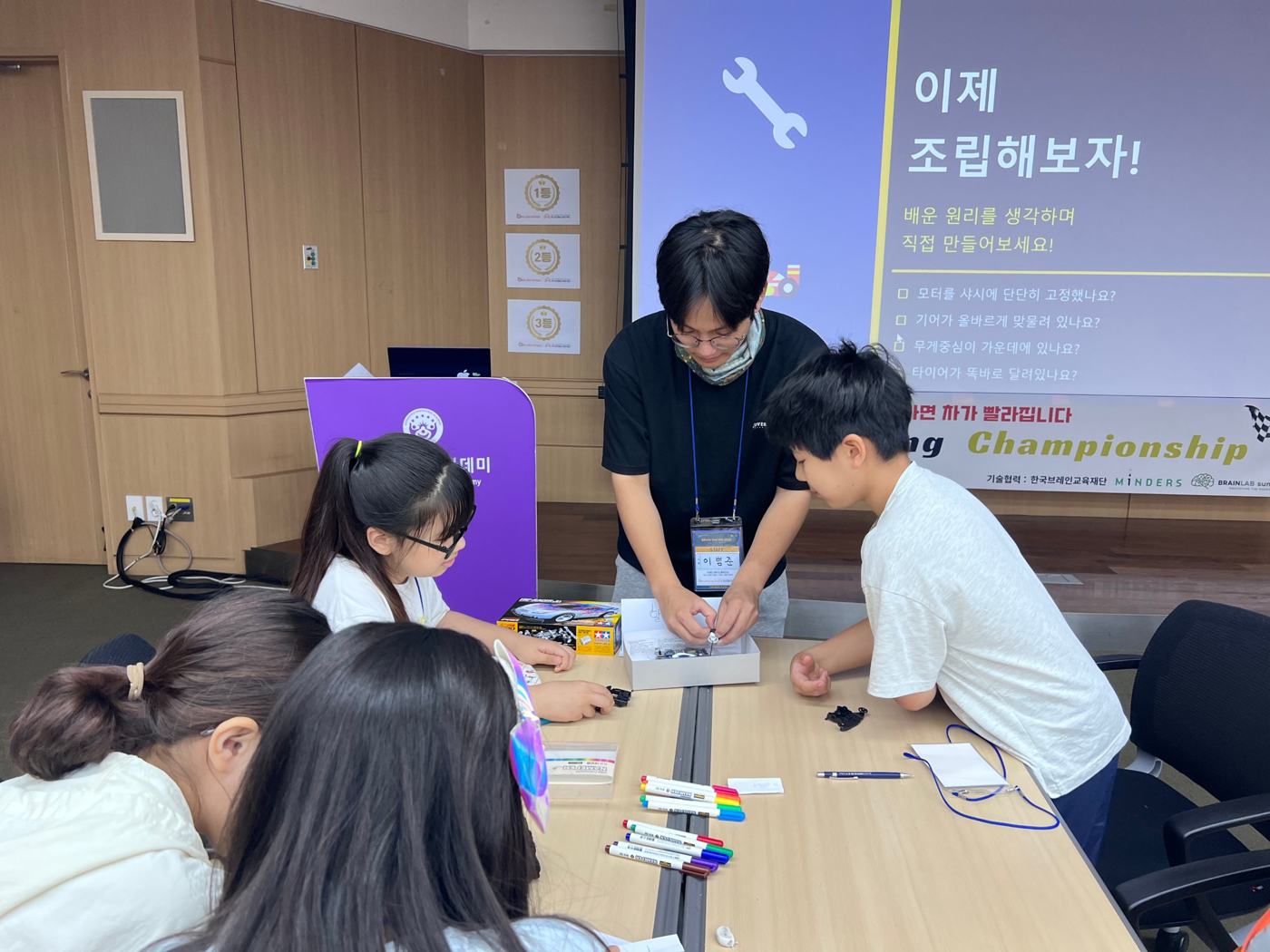 강사와 함께 모터와 기어를 조립하는 아이들